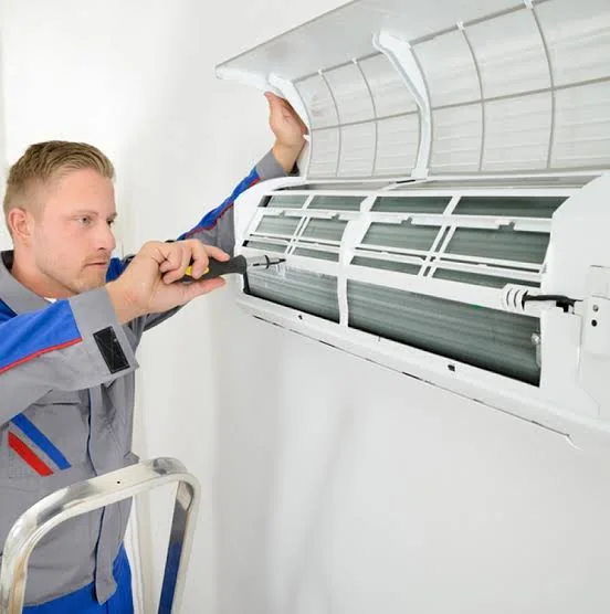 Stock photo of a technician inspecting an indoor air-conditioning unit