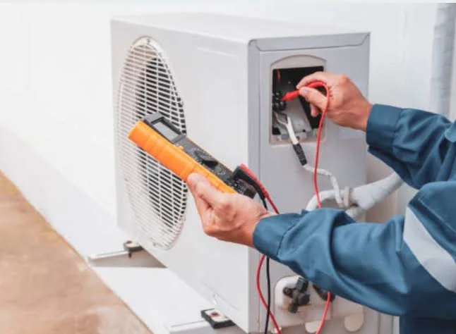 Stock photo of a technician using a meter to test HVAC electrical controls